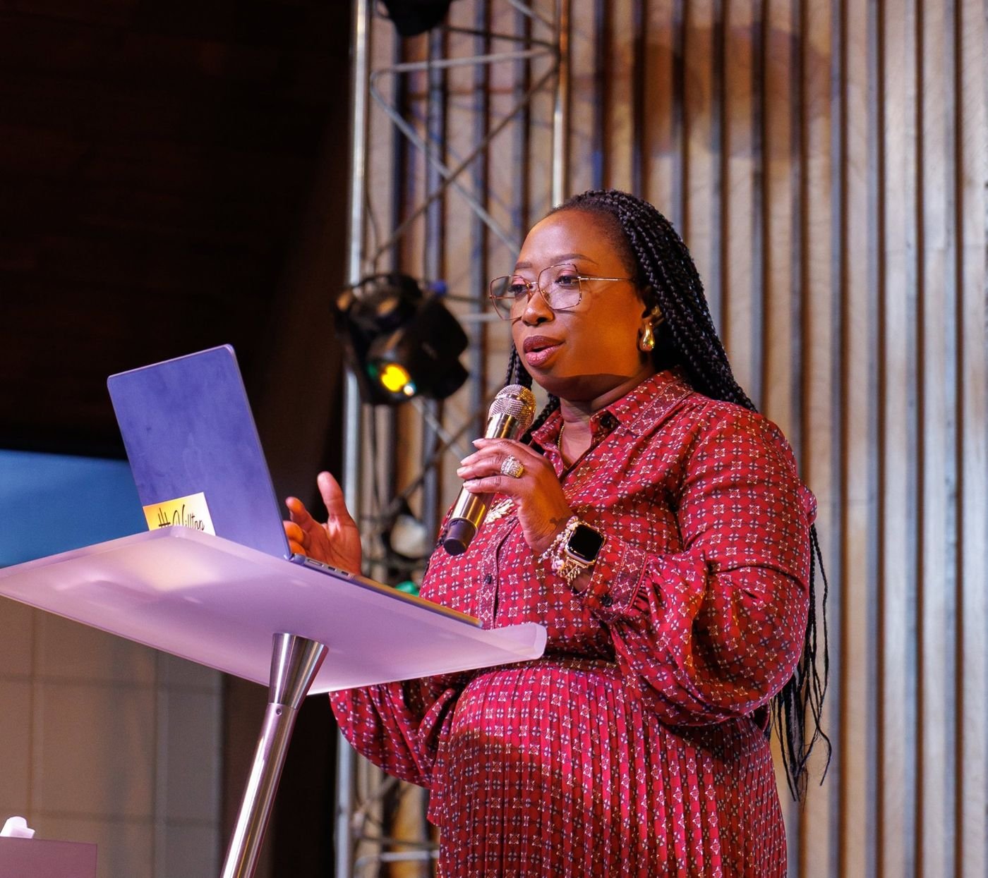 Kemi teaching from a podium with a microphone